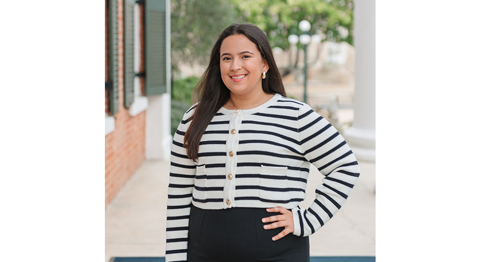 Outdoor portrait of a young woman wearing a black-and-white striped top.